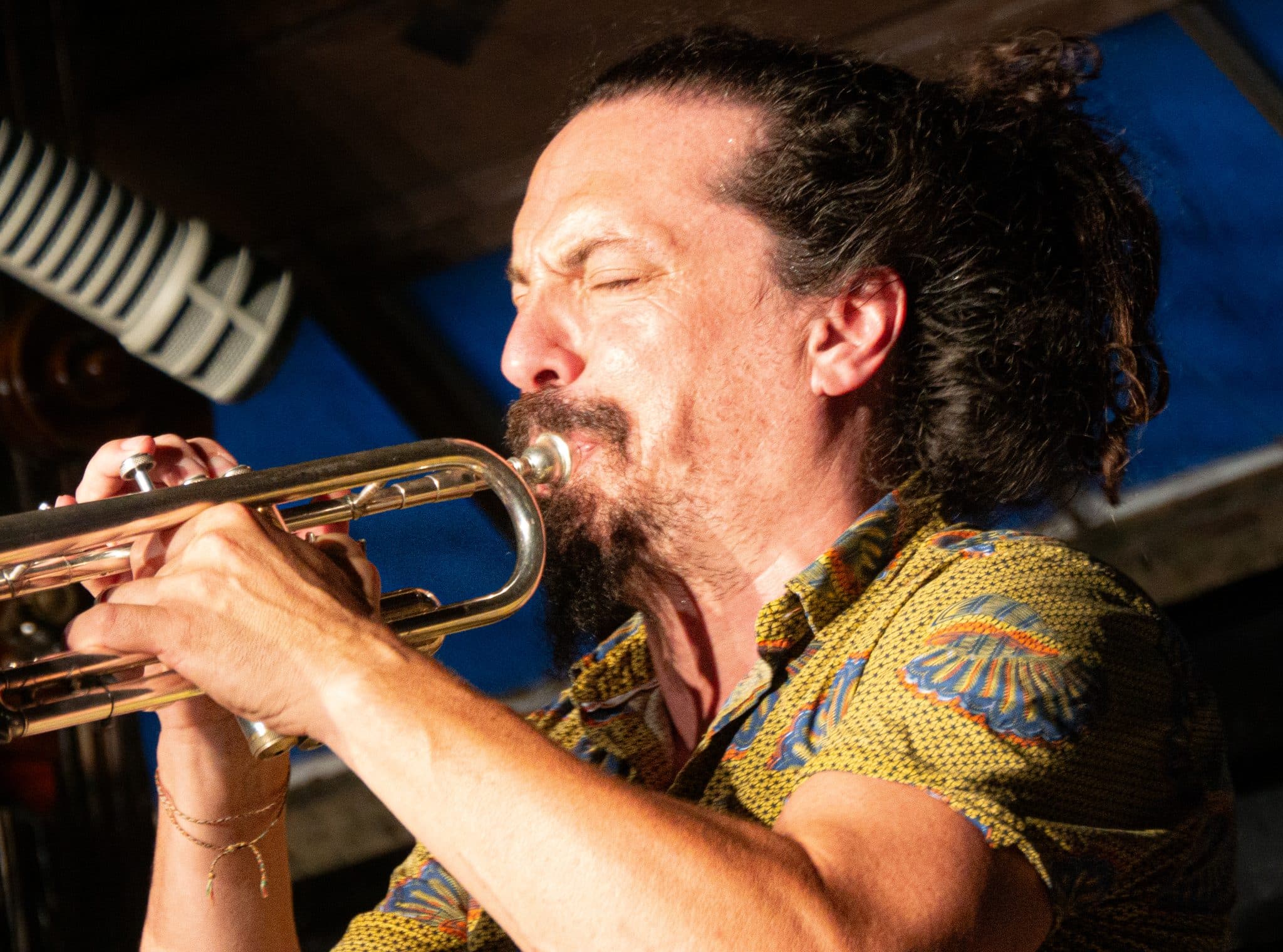 Close up of of Luis Vincente playing trumpet with his eyes closed.